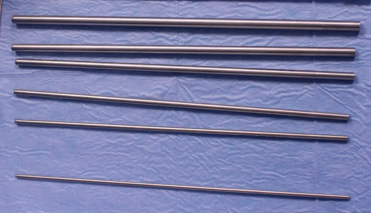 A set of metal telescoping Alken dilators laid side by side.